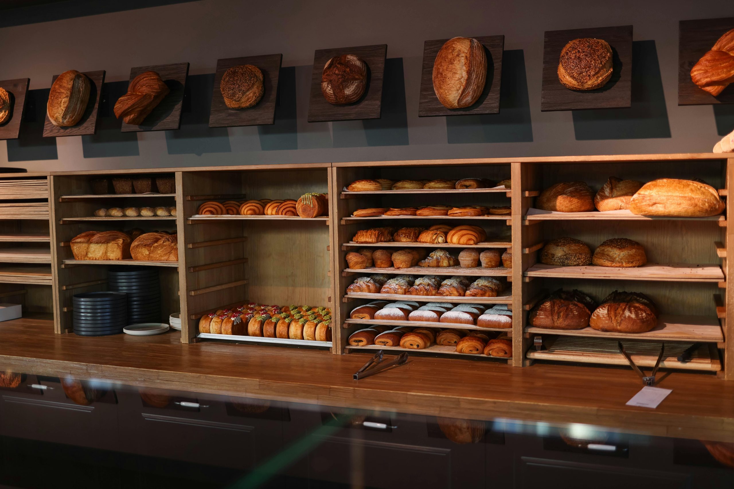 A display of freshly baked bread and pastries in a cozy artisan bakery interior.